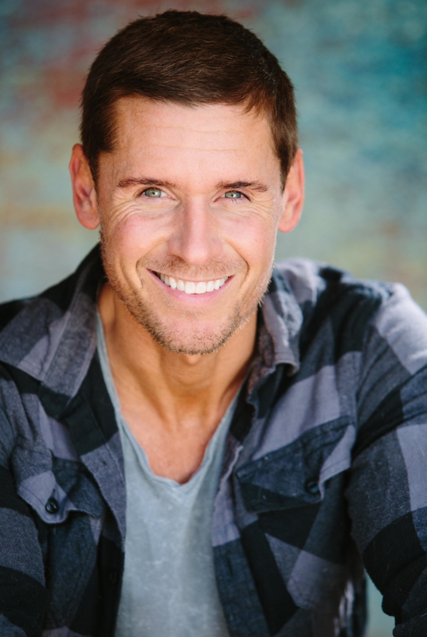 Actor, Linc Hand, smiling and relaxed in a blue flannel.
